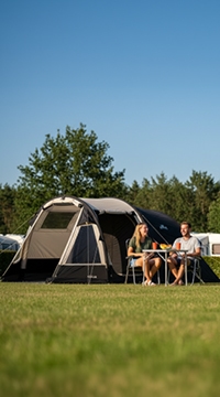 Tent met twee kampeerders aan tafel